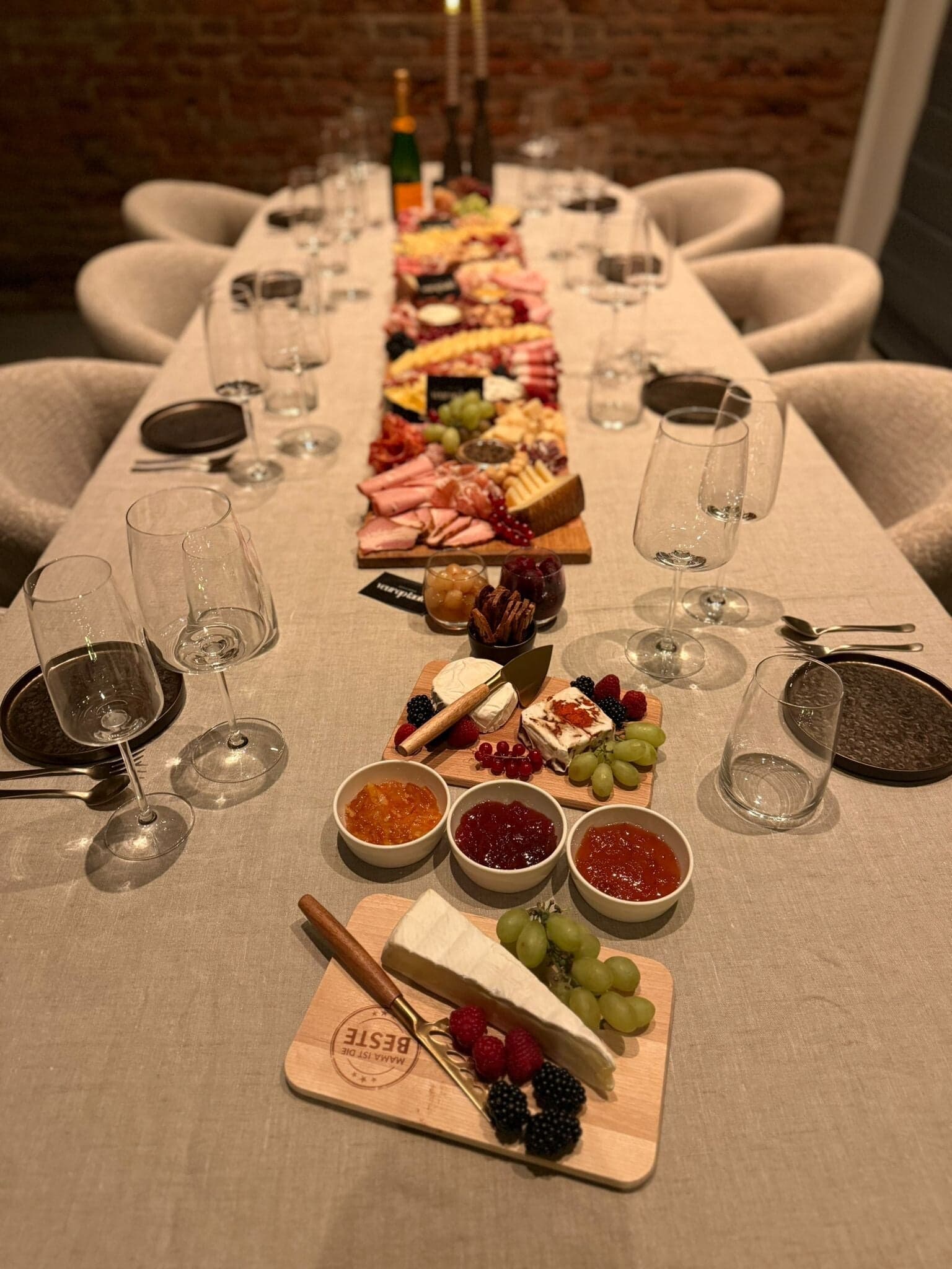 Wijnproeverij aan een lange gedekte tafel met borrelplanken